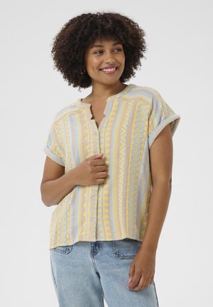 Chemise à manches courtes rayée jaune et bleue avec un bouton à l'avant et un col rond, présentant des motifs géométriques et une coupe décontractée.