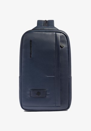 Mochila de cuero azul marino con textura suave, cierre de cremallera, detalle del logotipo en el frente y una forma rectangular elegante.