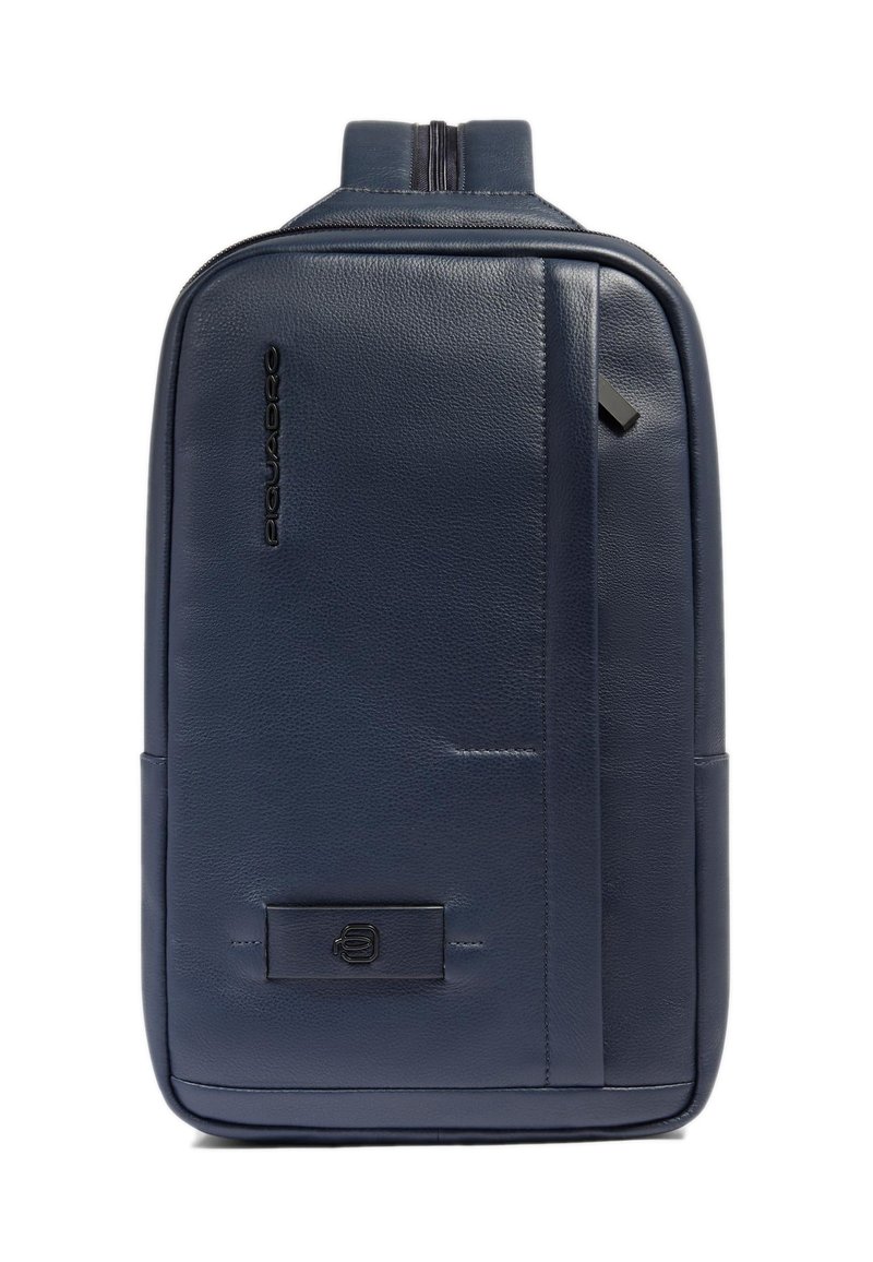 Marineblauwe leren rugzak met een gladde textuur, voorzien van een ritssluiting, logo detail aan de voorkant en een slank, rechthoekig ontwerp.