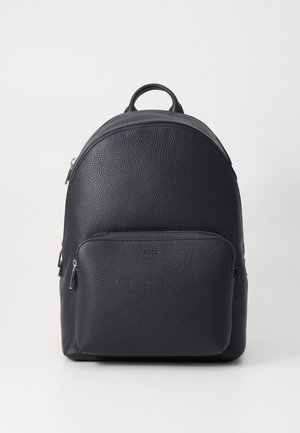 Sac à dos en cuir noir, avec un design arrondi, une surface texturée, une poignée supérieure et une poche zippée à l'avant.