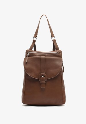 Sac en cuir marron porté à l'épaule avec rabat à boucle sur le devant, poche zippée sur le dessus et bretelles réglables sur fond blanc.