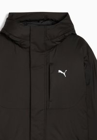 Sorte polstret jakke med høj krave, der har et hvidt Puma-logo på brystet og en glat, struktureret stof.
