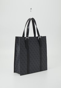 Svart tygväska med mönstrad textil och dubbla plana handtag, silver detaljer, rektangulär form och en strukturerad design.