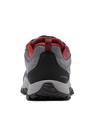 Szare wodoodporne buty trekkingowe z czerwonymi akcentami, teksturowana siateczkowa cholewka, czarna wsparcie pięty i wytrzymała podeszwa zapewniająca przyczepność na zewnątrz.