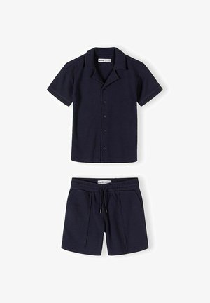 Cămașă bleumarin cu mâneci scurte, nasturi și guler, și pantaloni scurți cu șnur asortați, ambele dintr-un material texturat.