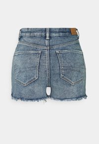 Farkkuminihame haalistuneessa sinisessä sävyssä, jossa on rispaantuneet reunat, kaksi takataskua ja vyötärönauha. Taskujen välissä pieni leikattu aukko.