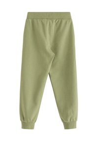 Lyst grønne joggerbukser lavet af blødt stof, med elastisk talje og mansjetter ved anklerne for en afslappet pasform.