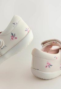 Helle pinke Schuhe aus synthetischem Leder mit floralem Muster in Pink und Lila. Sie besitzen eine weiße Gummisohle und einen Klettverschluss.
