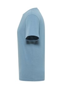 Jasnoniebieska koszulka bawełniana z okrągłym dekoltem, krótkimi rękawami i prostym krojem. Na materiale brak widocznych wzorów lub logo.