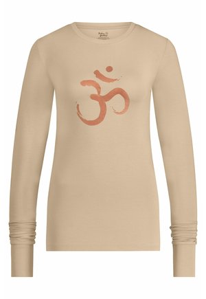 Chemise à manches longues beige clair en tissu doux, ornée d'un imprimé central orange du symbole Om avec une apparence légèrement texturée.