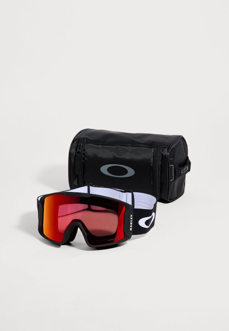 Black Oakley ski goggles with orange tinted lenses and a black carrying case with a grey Oakley logo on a white background.