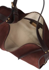 Bruin suède handtas met een ritssluiting, leren accenten en een beige stoffen voering met binnenzakken.