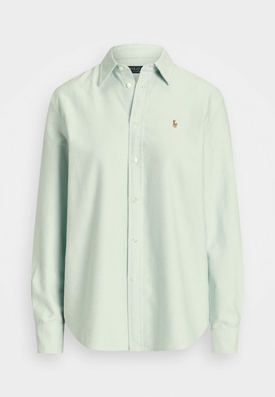 Camisa de botão de manga longa verde menta clara, feita de algodão. Apresenta um colarinho e um pequeno logótipo bordado no peito.