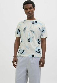 Camiseta de manga corta de color claro con un patrón floral en tonos azules y negros. Hecha de tela suave, con escote redondo y un fit relajado.