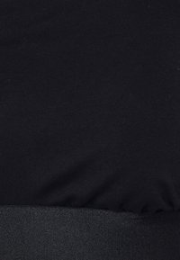 Tecido preto com uma textura suave, adornado com uma faixa elástica mais escura na borda inferior, fundindo-se perfeitamente com o material principal.