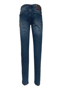 Tmavě modré džíny z denimu s úzkým střihem, pěti kapsami a texturovanou nášivkou na pásku. Mají zakřivené zadní kapsy a mírné vyblednutí.