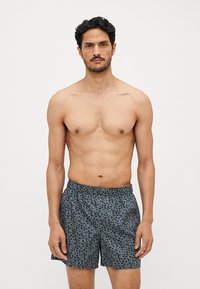 Shorts de bain pour hommes en gris foncé avec un motif floral discret, taille élastique et tissu léger et respirant.