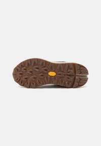 Sola de bota de caminhada com um padrão de ranhura robusto e multidirecional em borracha marrom, com um proeminente logo Vibram amarelo no centro.