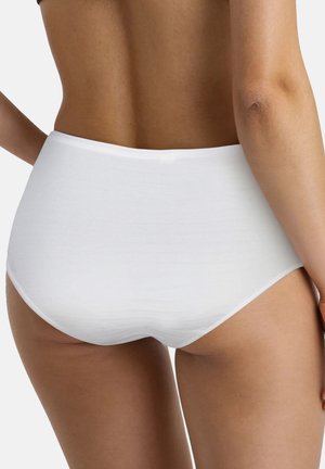 Vrouw die witte naadloze onderkleding met volledige bedekking draagt, gezien van de onderrug tot de bovenbenen tegen een effen achtergrond.