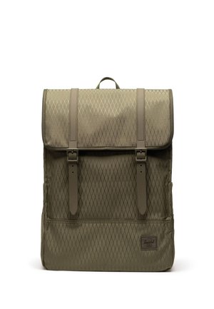 Khakigrüner Rucksack mit Rautenmuster, zwei vorderen Schnallenriemen, oberem Tragegriff und kleinem rechteckigem Markenetikett unten rechts.