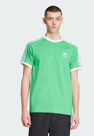 Green cotton t-shirt with white crew neck and sleeve trims, featuring three white stripes on each shoulder and an adidas logo on the chest.