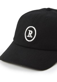 Svart ulllue med et hvitt broderte sirkellogo med et "R" i midten, strukturert design og buet skjerm.