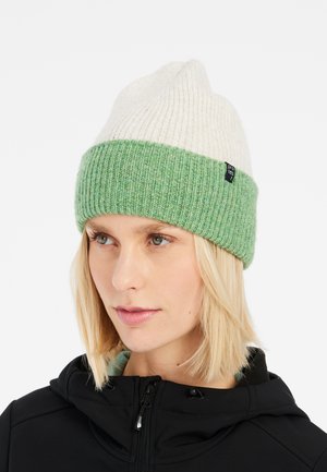 Knit beanie with a cream top half and a green ribbed lower band. Features a subtle brand tag on the side. Soft texture and fitted design.