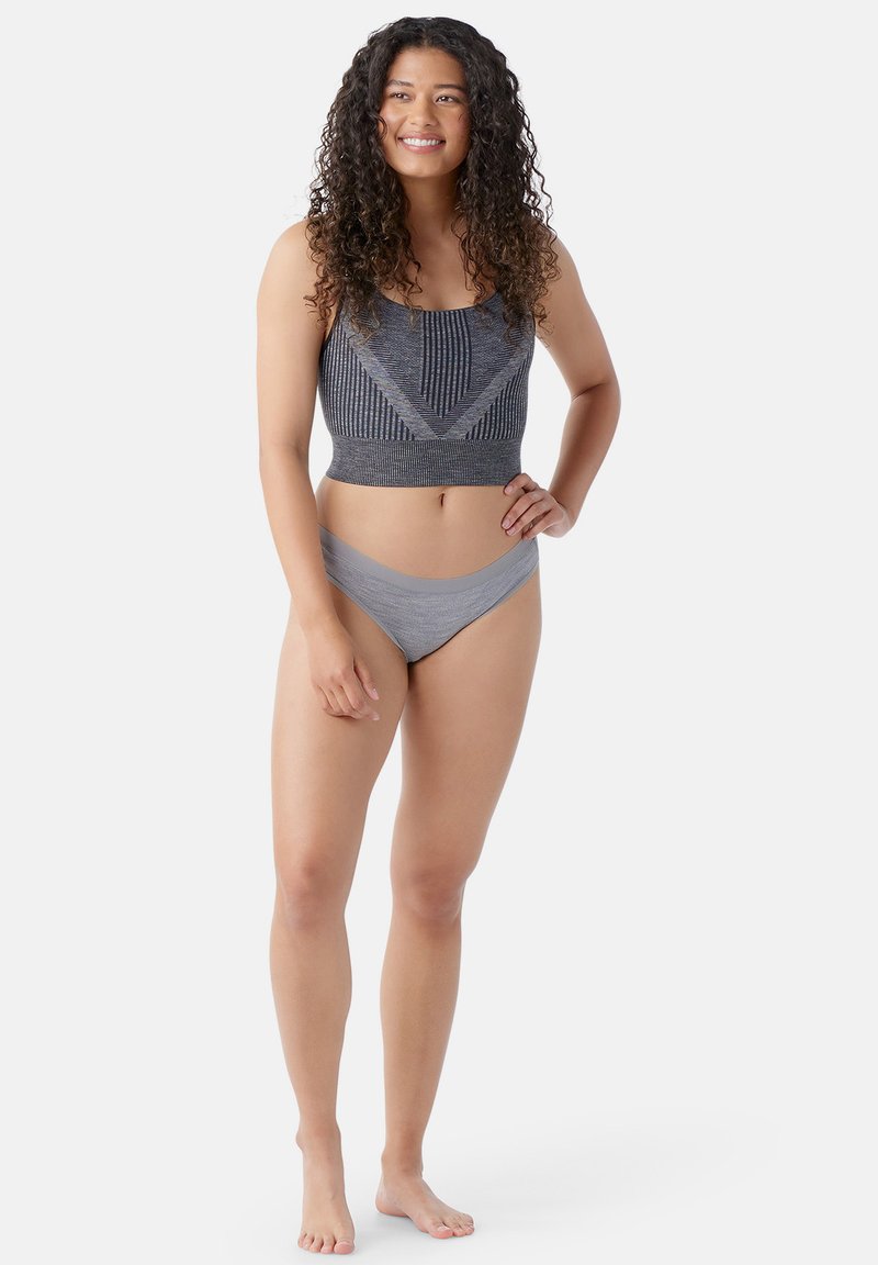 Grijze sportcrop top met verticale en diagonale patronen, gecombineerd met bijpassende bikini-stijl ondergoed. Zacht, rekbaar materiaal; aansluitend ontwerp.