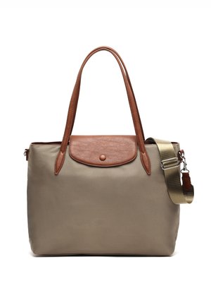 Sac fourre-tout beige avec rabat et poignées en cuir marron, doté d'une bandoulière beige ajustable avec fermoir métallique.