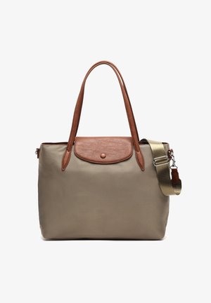 Beige tote bag with brown leather flap and handles, featuring an adjustable beige shoulder strap with metal clasp.