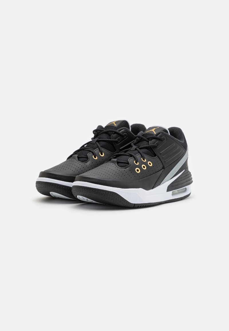 Schwarze Sportschuhe mit einer strukturierten Lederoberfläche, goldenen Akzenten, durchbrochenen Details und einer weißen Zwischensohle mit sichtbarem Luftkissen.