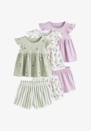 Barn iført en lysegrøn top med broderede blomster og matchende grønne og hvide stribede shorts med blonder.