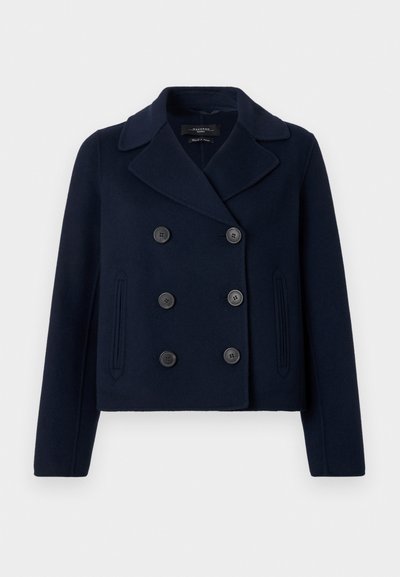 Cappotto peacoat in misto lana blu navy con apertura doppiopetto, grandi bottoni neri, ampio colletto a punta e tasche laterali. Texture liscia.