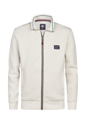 Weißer Reißverschlussjacke aus strukturiertem Stoff, mit stehendem Kragen in Grün und Blau gestreift und einem aufgenähten Logo auf der Brust.