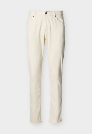 Παντελόνι σε εφαρμοστή γραμμή, εκρού χρώματος, με κουμπί στο μπροστινό μέρος, φερμουάρ και σχέδιο με πέντε τσέπες σε απλό φόντο.