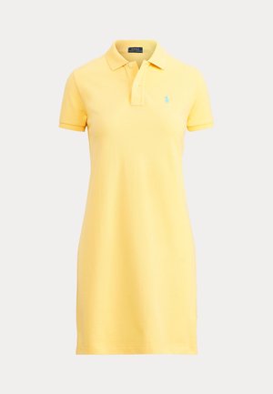 Polo-Kleid aus weichem gelben Baumwollstoff, mit kurzen Ärmeln und einem Kragen mit drei Knöpfen, ausgestattet mit einem kleinen blauen Logo auf der linken Brust.