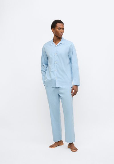 Svetlo modra bombažna pižama z zgornjim delom na gumbe z ostrim ovratnikom in dolgimi rokavi ter ujemajočimi ravnimi hlačami.