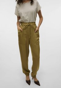 Pantalons de jogging vert olive avec taille élastique et cordon de serrage, dotés de poches latérales et de bords côtelés, associés à un t-shirt rayé.