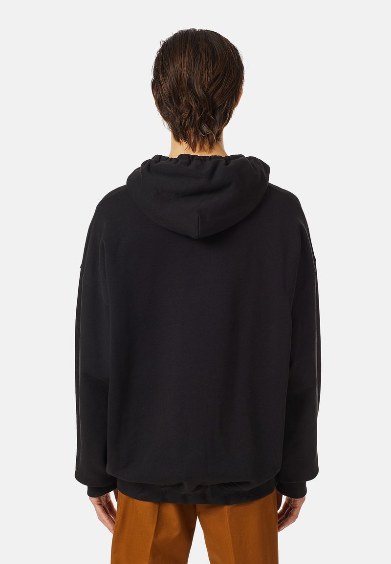 Haut de hoodie surdimensionné noir avec une capuche à cordon de serrage, des poignets et un ourlet côtelés. Le matériau semble doux et texturé, proposé dans une coupe décontractée.