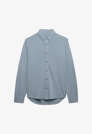Lyseblå langærmet skjorte med knapper, spidst krave og knapmanchetter, vist fladt mod en hvid baggrund.