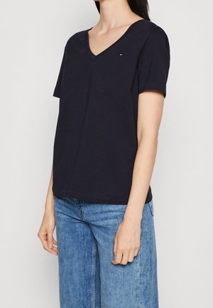 Camiseta de algodón de cuello en V en color navy, con mangas cortas y un pequeño logo en el lado izquierdo del pecho. Corte recto y ajuste relajado.