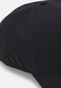 Črna bejzbol kapa z gladko teksturo tkanine, strukturirano zasnovo in tridimenzionalnim poudarkom na strani.