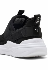 Czarne buty sportowe wsuwane z siateczkowej cholewki i elastycznym paskiem. Biała podeszwa z teksturowanym wzorem, z pętelką z napisem "SLIPTECH" na pięcie.