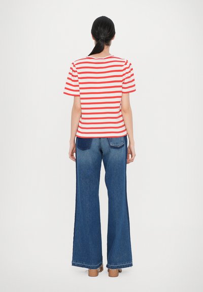 Striped red and white short-sleeve top paired with wide-leg blue denim jeans, featuring a raw hem and prominent side seams.