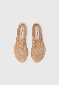 Des chaussures slip-on en toile de jute beige, dotées d'un motif en losanges, d'une texture lisse et d'un intérieur doux avec une semelle intérieure arborant un logo.