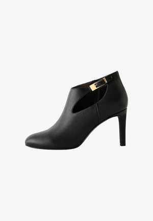 Must must kuninga nahast saapad lõike detailiga, kuldsete aksessuaaridega, terava varbaga ja peene kõrge kontsaga. Sile tekstuur ja voolujooneline disain.