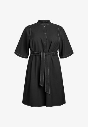 Mustast särgist kleit lühikeste varrukatega, nööbitava esiosaga, kraega ja sobiva kangast vööga. Omadusteks on kontrastsed valged õmblused.