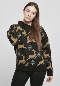 Zwarte gebreide trui met een patroon van gouden rendieren en witte sneeuwvlokken. Ribbelvormige ronde hals en manchetten. Zachte textuur.