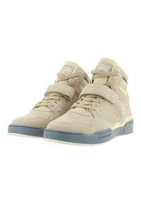 Beige vysoké tenisky vyrobené z semiše s gumovou podrážkou, s perforovanou špičkou, zapínáním na pásek a detailem loga na boku.