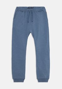 Blaue Jogginghosen mit elastischem Bund, Kordelzug, Seitentaschen, Knie-Nähten und gerippten Knöcheln auf weißem Hintergrund.